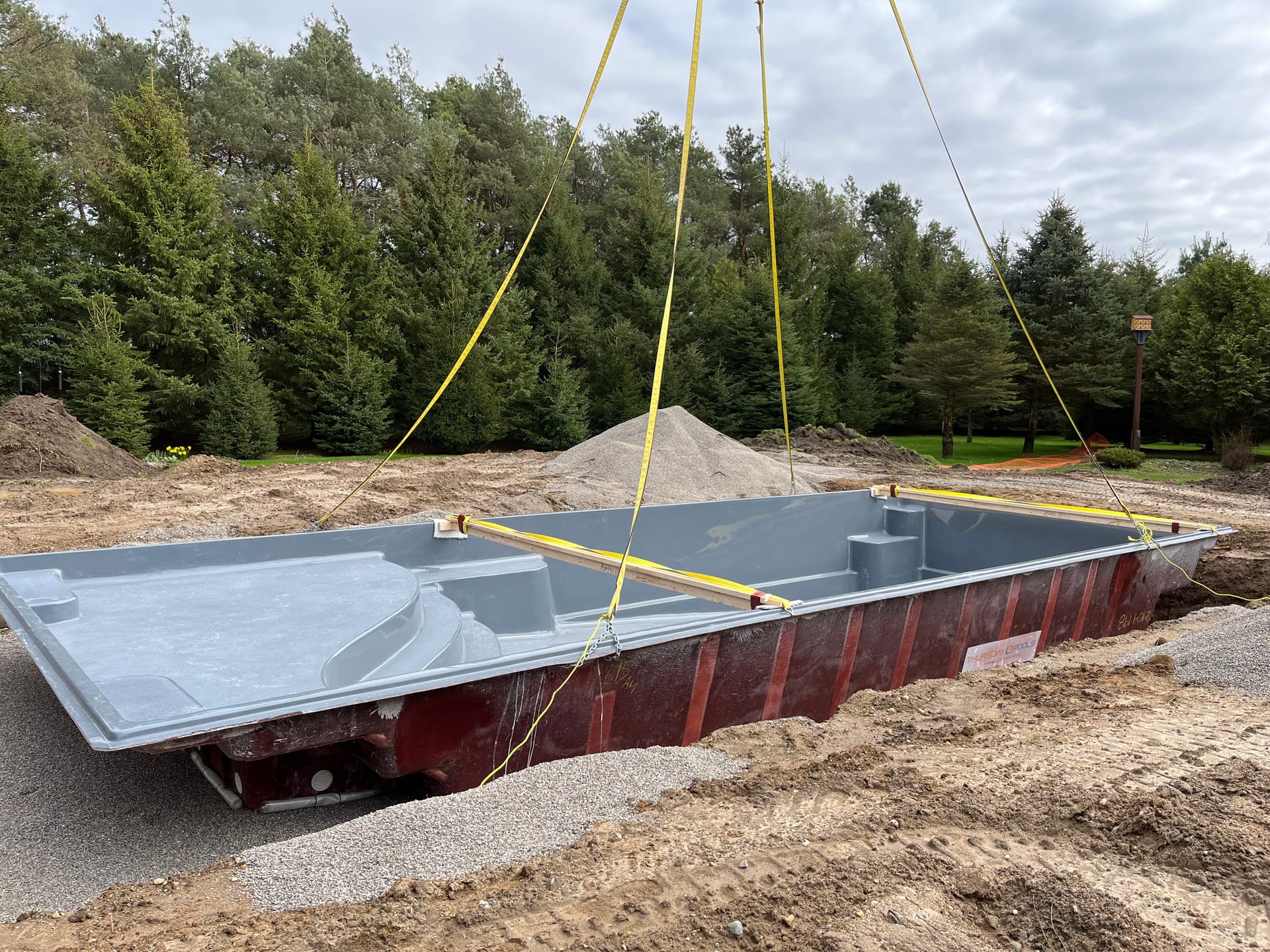 Fiberglass pool shell being lowered into place