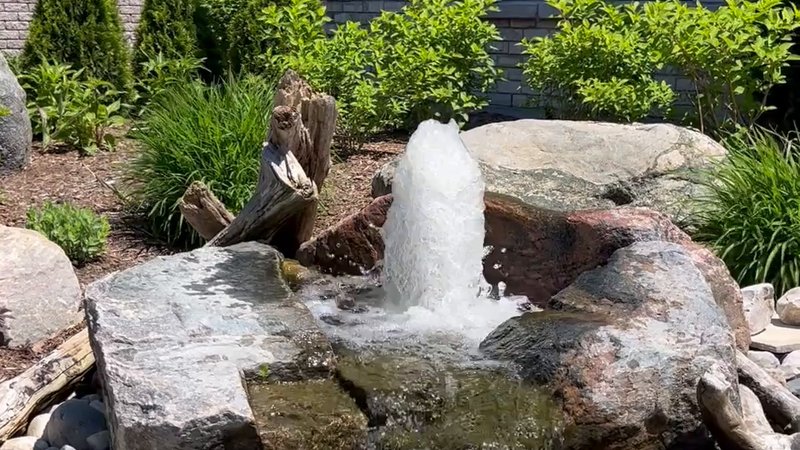 Bubbling rock water feature spilling over natural stone