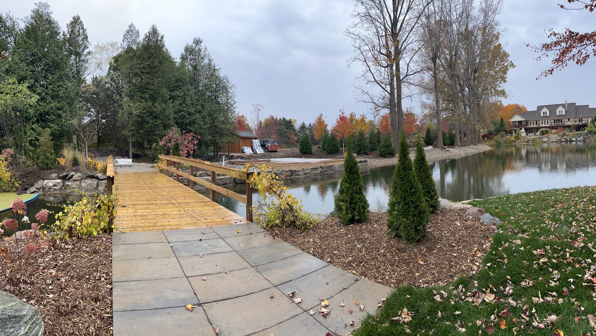 Pond with wooden bridge and natural landscaping