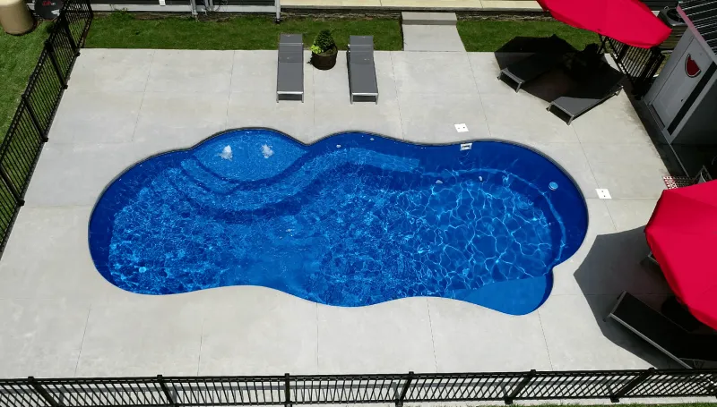 Freeform fiberglass pool on a concrete patio